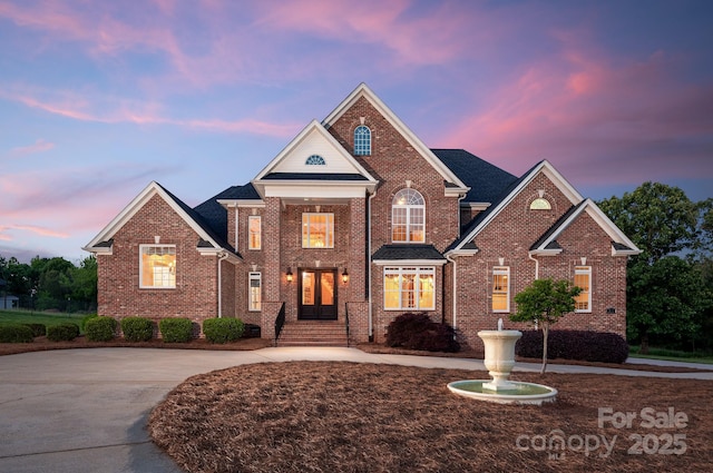 view of front of home with brick siding and curved driveway