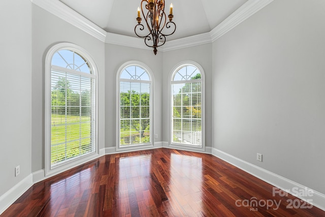 unfurnished room featuring a chandelier, dark wood-type flooring, baseboards, and ornamental molding