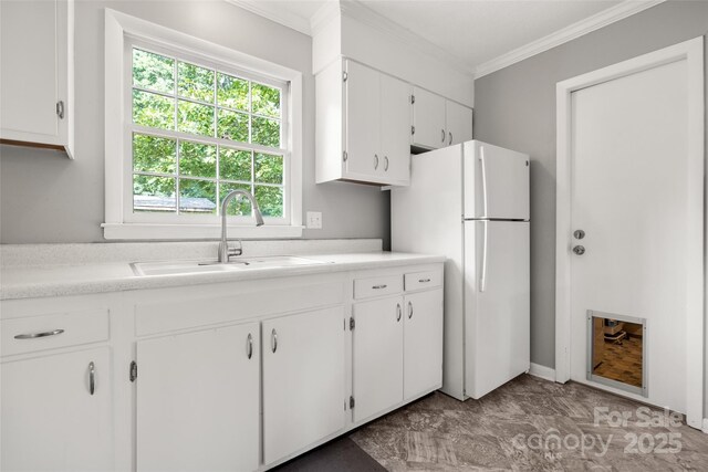 3900 Langley Rd, Charlotte, NC 28215 - kitchen with a sink, freestanding refrigerator, crown molding, white cabinets, and light countertops