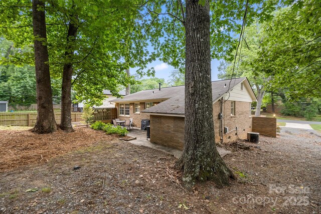 3900 Langley Rd, Charlotte, NC 28215 - back of house with brick siding, fence, a patio, and a shingled roof
