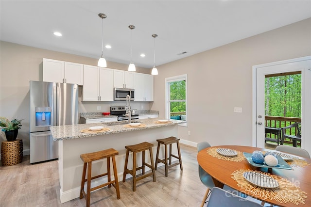 43 Clarks Chapel Ext, Weaverville, NC 28787 - kitchen with stainless steel appliances, light wood-type flooring, a kitchen island with sink, a breakfast bar, and recessed lighting
