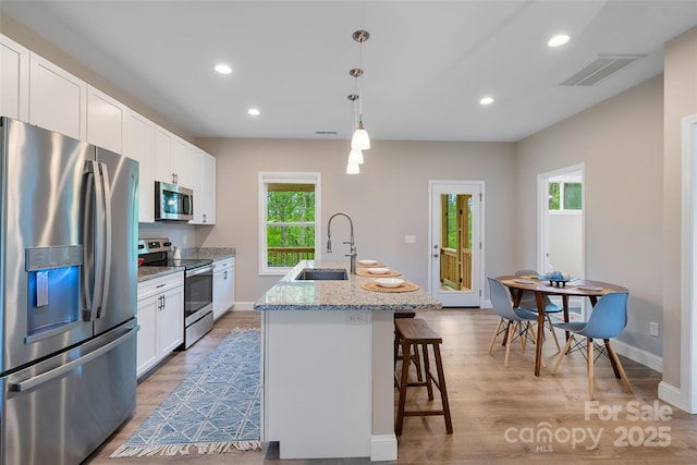 43 Clarks Chapel Ext, Weaverville, NC 28787 - kitchen with stainless steel appliances, a sink, an island with sink, white cabinetry, and a breakfast bar area
