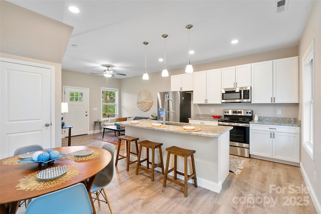 43 Clarks Chapel Ext, Weaverville, NC 28787 - kitchen featuring stainless steel appliances, an island with sink, light wood-style flooring, white cabinets, and recessed lighting