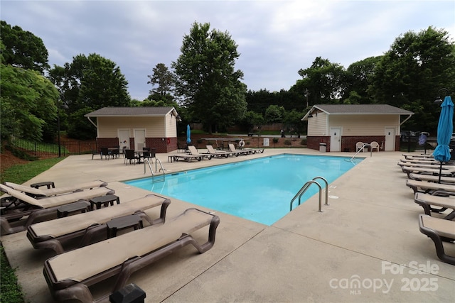 1000 E Woodlawn Rd Unit 107, Charlotte, NC 28209 - community pool with a patio area, an outbuilding, and view of wooded area