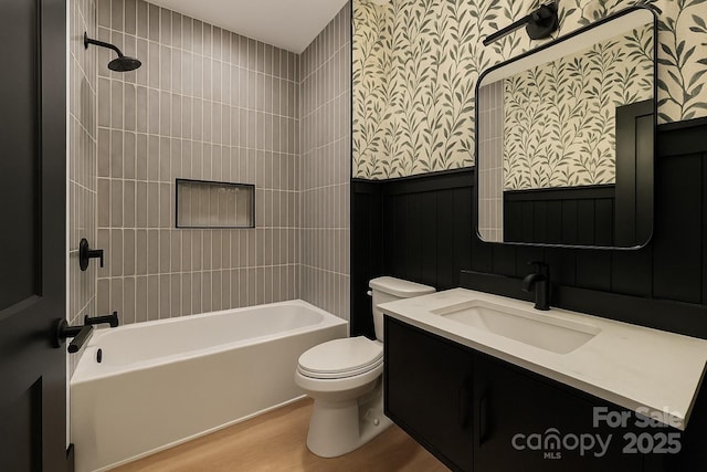 415 S Boyd St, Gastonia, NC 28052 - bathroom with wallpapered walls, washtub / shower combination, toilet, wood finished floors, and vanity