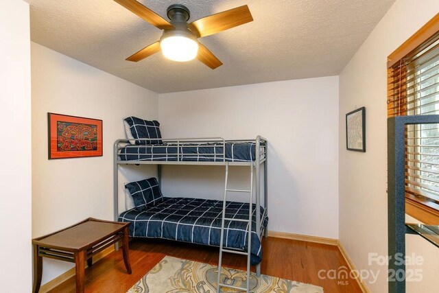 491 Mckenzie Way S, Old Fort, NC 28762 - bedroom with wood finished floors, baseboards, ceiling fan, and a textured ceiling