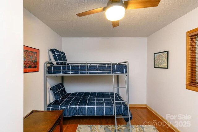 491 Mckenzie Way S, Old Fort, NC 28762 - bedroom featuring wood finished floors, a textured ceiling, ceiling fan, and baseboards