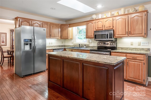 287 Anne St, Rutherfordton, NC 28139 - kitchen with stainless steel appliances, a sink, a skylight, ornamental molding, and light wood-style flooring