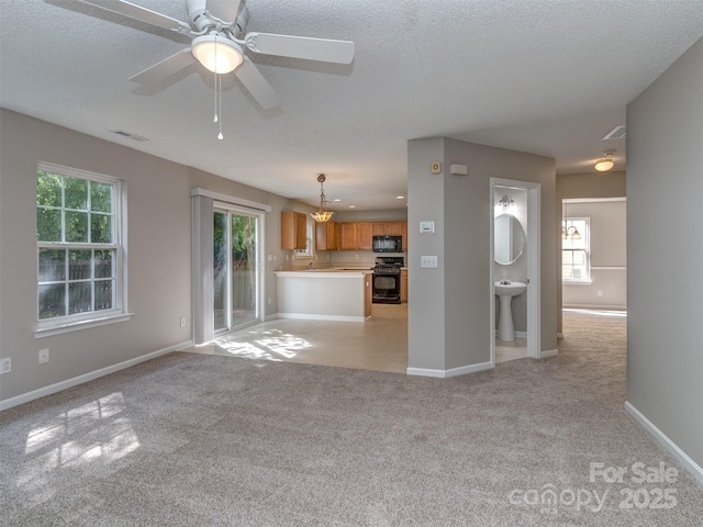 4208 Everest Dr, Gastonia, NC 28054 - unfurnished living room with light carpet, a chandelier, ceiling fan, baseboards, and a textured ceiling