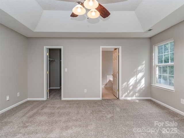 4208 Everest Dr, Gastonia, NC 28054 - unfurnished bedroom featuring a raised ceiling, carpet flooring, a walk in closet, and ceiling fan