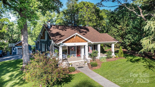 225 Rectory Hill Pl SW, Lenoir, NC 28645 - view of front facade with covered porch, a chimney, a front yard, a shingled roof, and an outbuilding