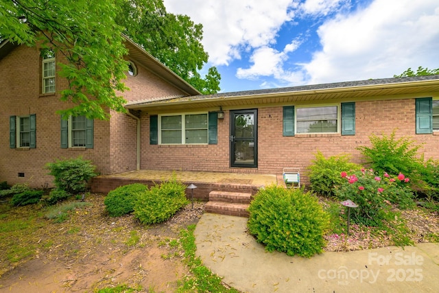 ranch-style home featuring brick siding and crawl space