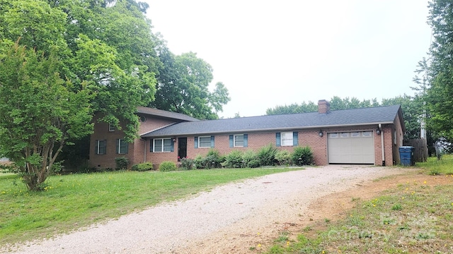 view of front of property featuring an attached garage, driveway, brick siding, a chimney, and a front yard