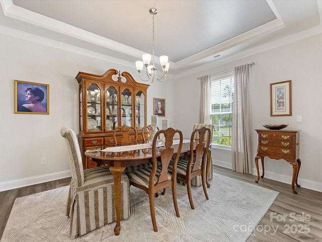 603 Southstone Dr, Matthews, NC 28104 - dining space featuring a raised ceiling, a chandelier, light wood finished floors, and baseboards