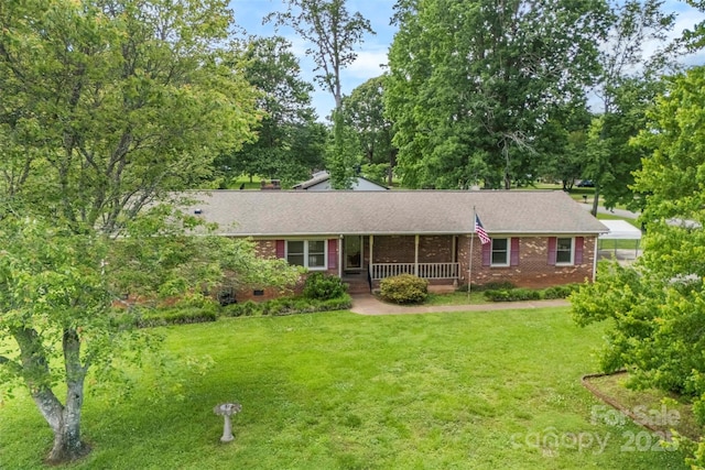 113 Helena St, Mount Holly, NC 28120 - ranch-style house with a porch, brick siding, a front yard, and roof with shingles