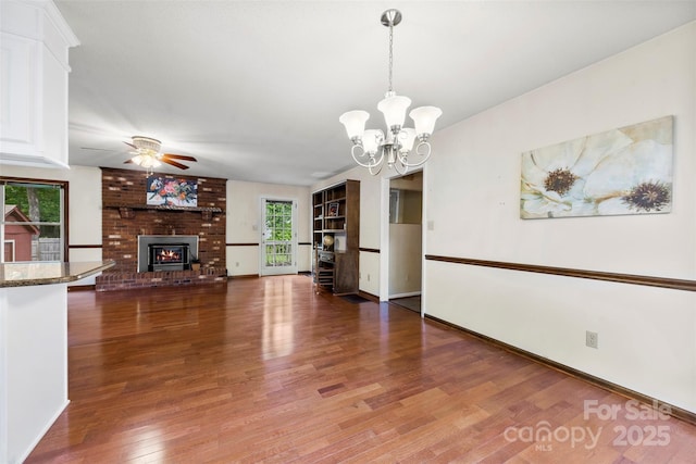 113 Helena St, Mount Holly, NC 28120 - unfurnished living room featuring a fireplace, ceiling fan, wood finished floors, a chandelier, and baseboards
