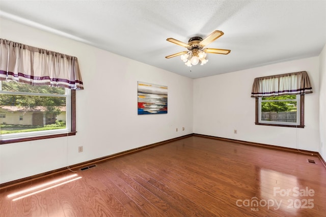 113 Helena St, Mount Holly, NC 28120 - empty room featuring plenty of natural light, wood finished floors, ceiling fan, and baseboards