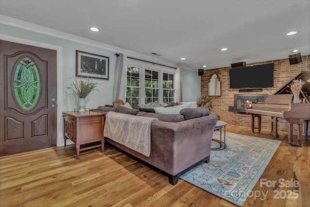 11 Chaz Ln, Candler, NC 28715 - living room featuring ornamental molding, light wood-style flooring, a fireplace, recessed lighting, and brick wall