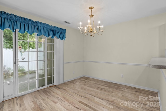 112 Dujon Ct, Mount Holly, NC 28120 - unfurnished dining area featuring a chandelier, healthy amount of natural light, light wood-style flooring, and baseboards