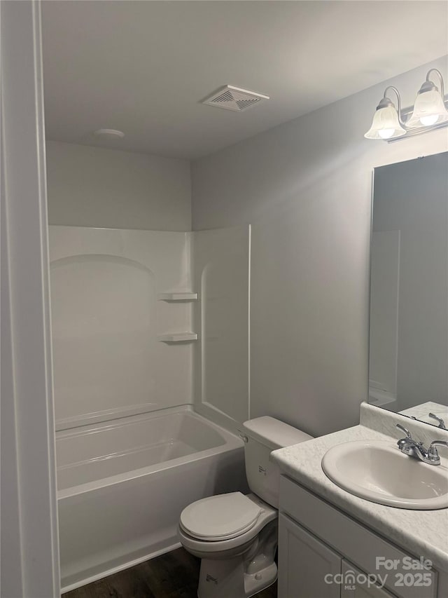 full bathroom featuring vanity, toilet, wood finished floors, and bathing tub / shower combination
