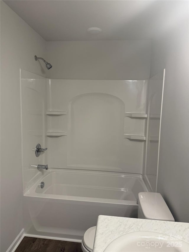 full bath featuring toilet, wood finished floors, bathing tub / shower combination, and baseboards