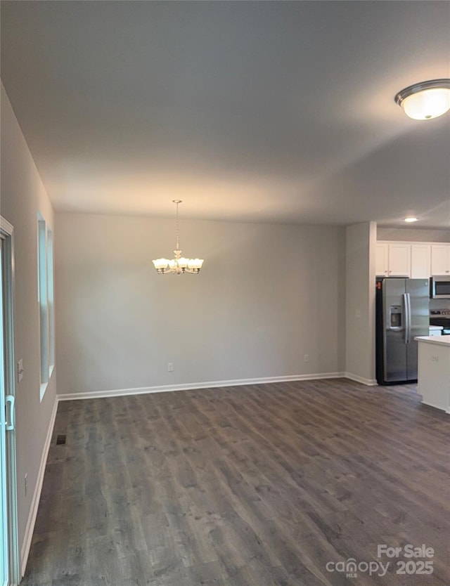 unfurnished dining area featuring a chandelier, dark wood-type flooring, baseboards, and recessed lighting