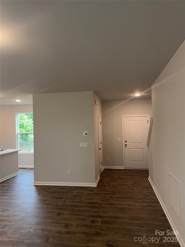 unfurnished room with dark wood-style floors, baseboards, and recessed lighting