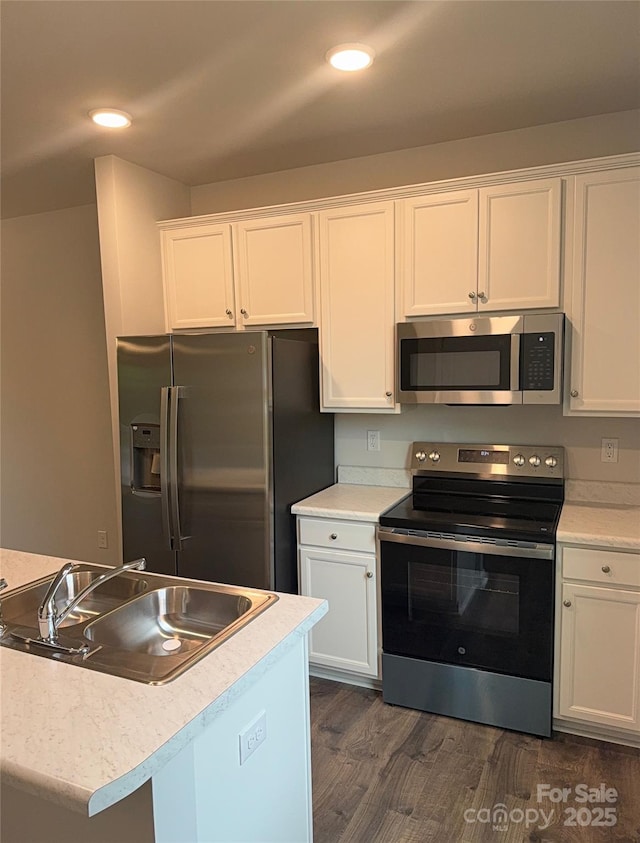 kitchen featuring stainless steel appliances, a sink, white cabinets, and recessed lighting