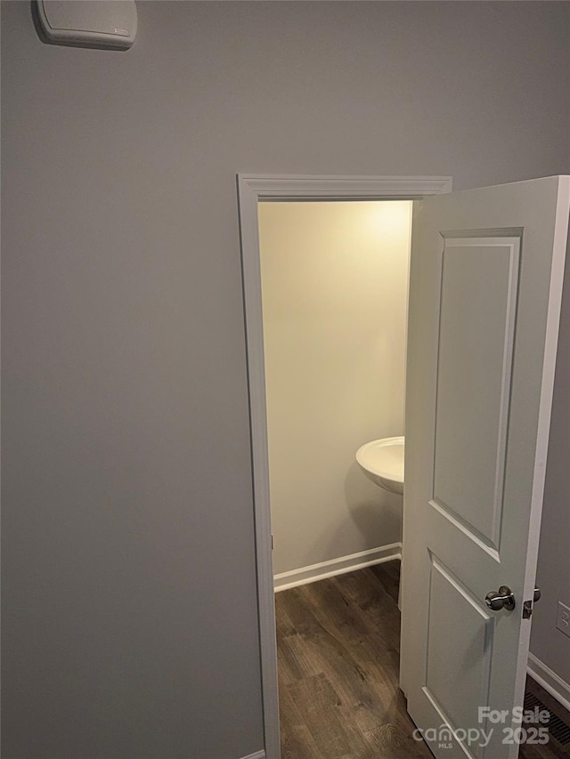 bathroom with wood finished floors, baseboards, and an AC wall unit
