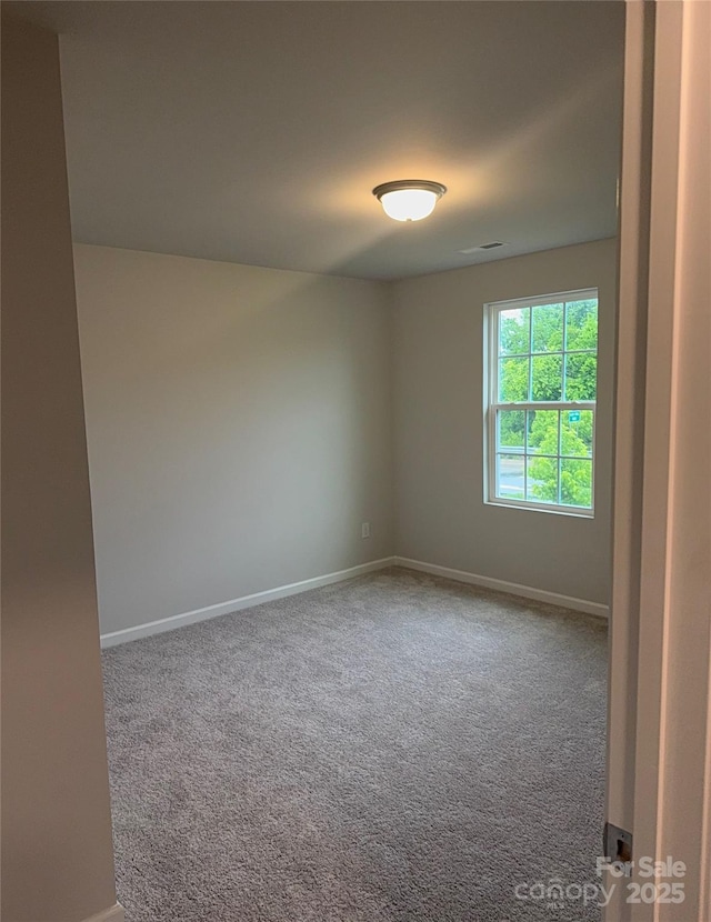 carpeted empty room with baseboards