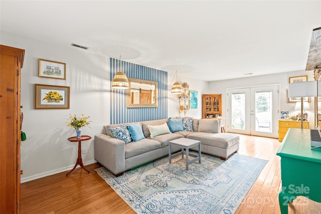living area featuring wood finished floors, french doors, and baseboards