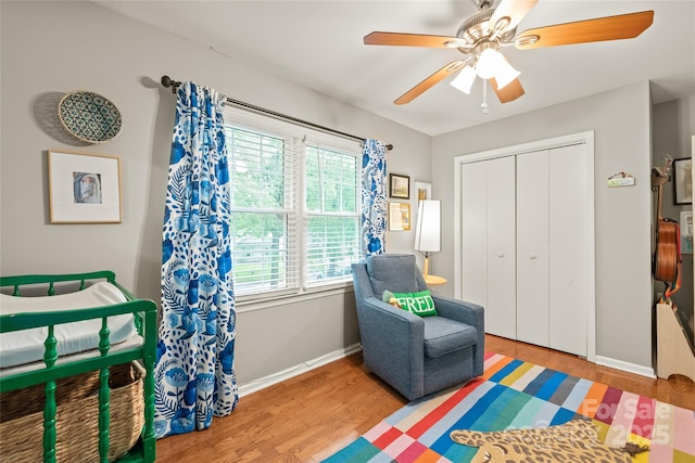 bedroom featuring wood finished floors, a closet, baseboards, and ceiling fan