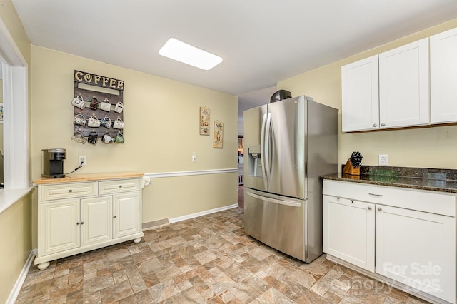 3104 Canterbury St, Greensboro, NC 27408 - kitchen with stainless steel refrigerator with ice dispenser, stone finish flooring, baseboards, and white cabinetry