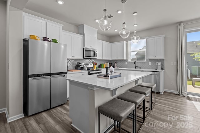 5625 Axil Ln, Charlotte, NC 28269 - kitchen featuring stainless steel appliances, a sink, recessed lighting, a center island, and wood finished floors