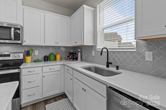 5625 Axil Ln, Charlotte, NC 28269 - kitchen featuring stainless steel appliances, a sink, white cabinets, and tasteful backsplash