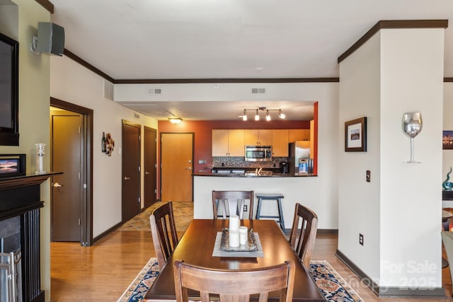 715 N Church St Unit 613, Charlotte, NC 28202 - dining space featuring a lit fireplace, light wood-type flooring, and baseboards