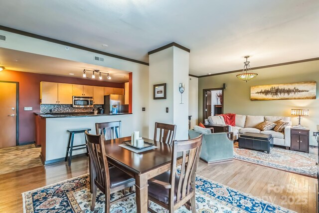 715 N Church St Unit 613, Charlotte, NC 28202 - dining space featuring light wood-type flooring and crown molding
