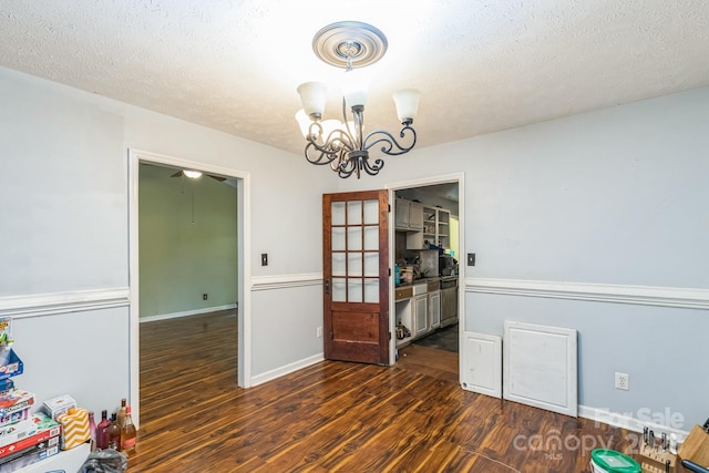 113 Stacy Ln, Raeford Township, NC 28376 - dining area featuring dark wood-type flooring, a chandelier, a textured ceiling, and baseboards