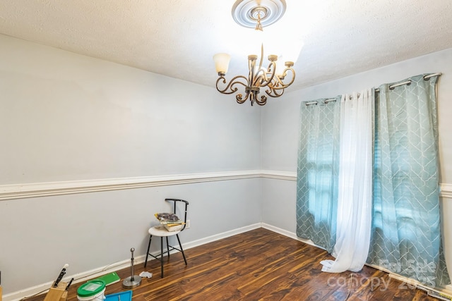 113 Stacy Ln, Raeford Township, NC 28376 - unfurnished room with a chandelier, wood finished floors, baseboards, and a textured ceiling