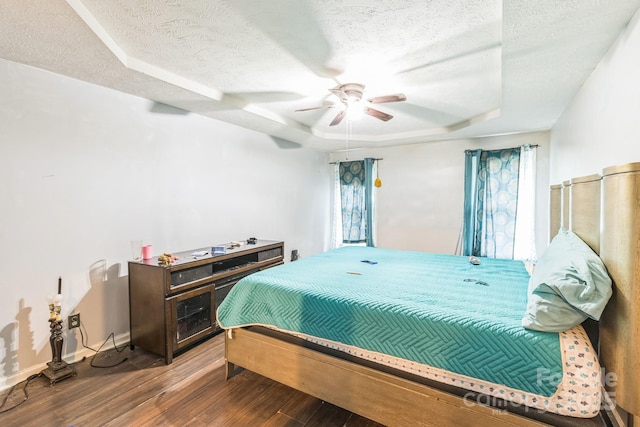 113 Stacy Ln, Raeford Township, NC 28376 - bedroom featuring a textured ceiling, wood finished floors, a tray ceiling, baseboards, and ceiling fan