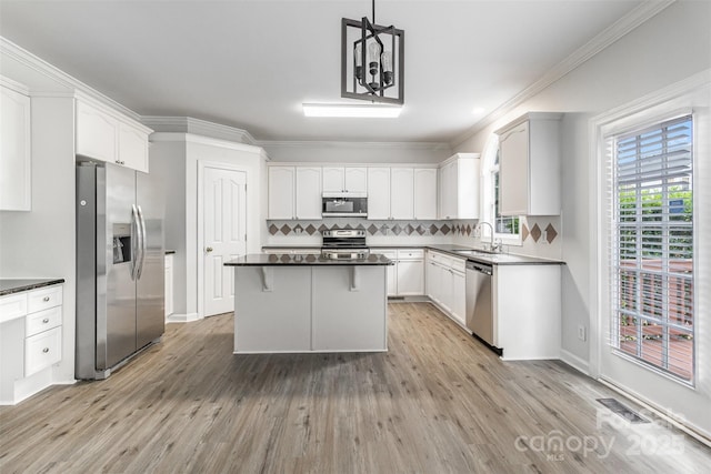 11526 Mcginns Trace Ct, Charlotte, NC 28277 - kitchen featuring appliances with stainless steel finishes, a sink, a kitchen island, tasteful backsplash, and light wood-style flooring