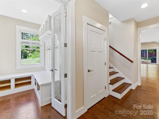 stairs with wood finished floors and recessed lighting
