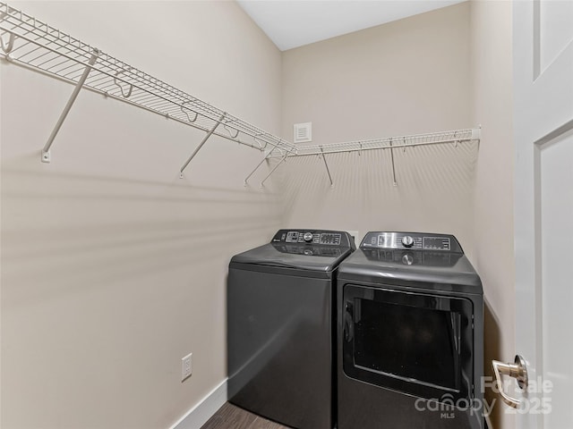 washroom with washing machine and dryer and baseboards