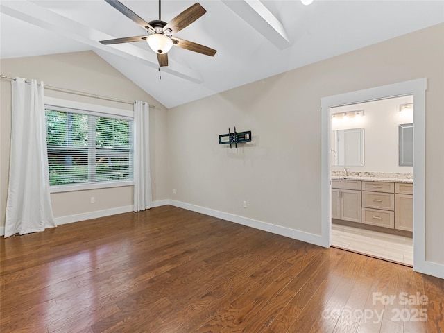 unfurnished bedroom with wood finished floors, baseboards, a sink, ceiling fan, and connected bathroom