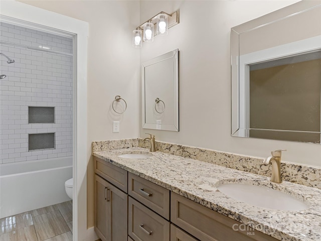 full bath featuring toilet, double vanity, and bathing tub / shower combination