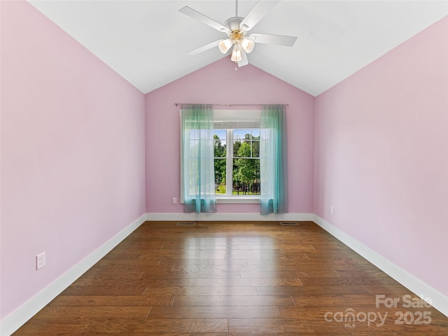 empty room featuring wood finished floors, a ceiling fan, vaulted ceiling, and baseboards