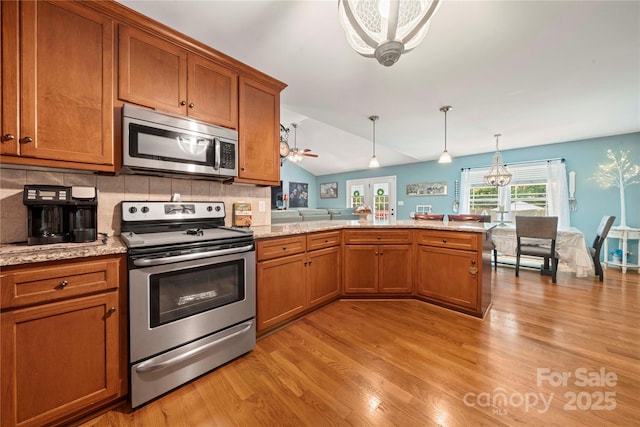 5764 Grassy Creek Rd, Denver, NC 28037 - kitchen featuring appliances with stainless steel finishes, brown cabinets, light wood-type flooring, and vaulted ceiling