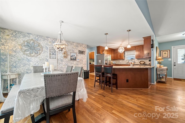 5764 Grassy Creek Rd, Denver, NC 28037 - dining area featuring wallpapered walls, healthy amount of natural light, a chandelier, and light wood-style flooring