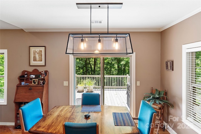 dining area featuring baseboards, wood finished floors, and ornamental molding