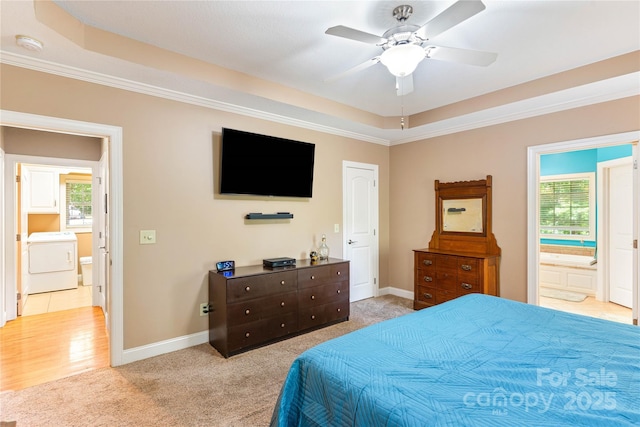 bedroom featuring washer / dryer, multiple windows, light colored carpet, a raised ceiling, and crown molding
